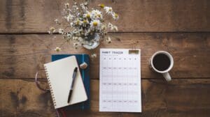 A habit tracker on a wood table. Person is focused on Building Good Habits and Beating Bad Ones
