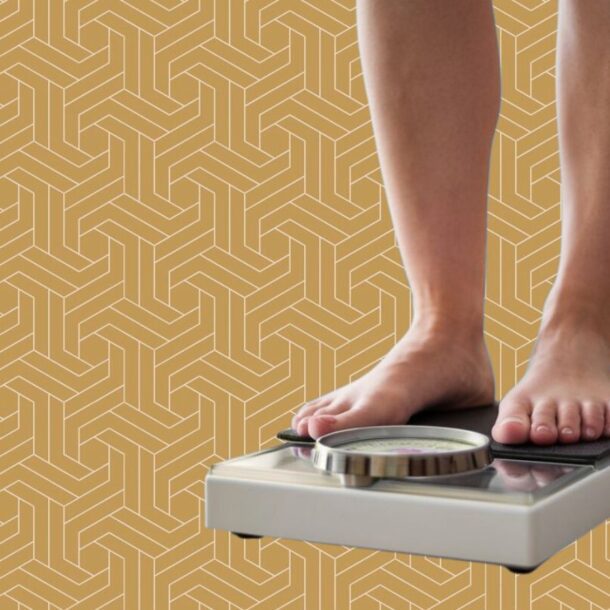 A person stands barefoot on a bathroom scale, symbolizing their fat loss journey, against a yellow geometric patterned background. The scale’s dial is visible, but the weight reading remains unclear.