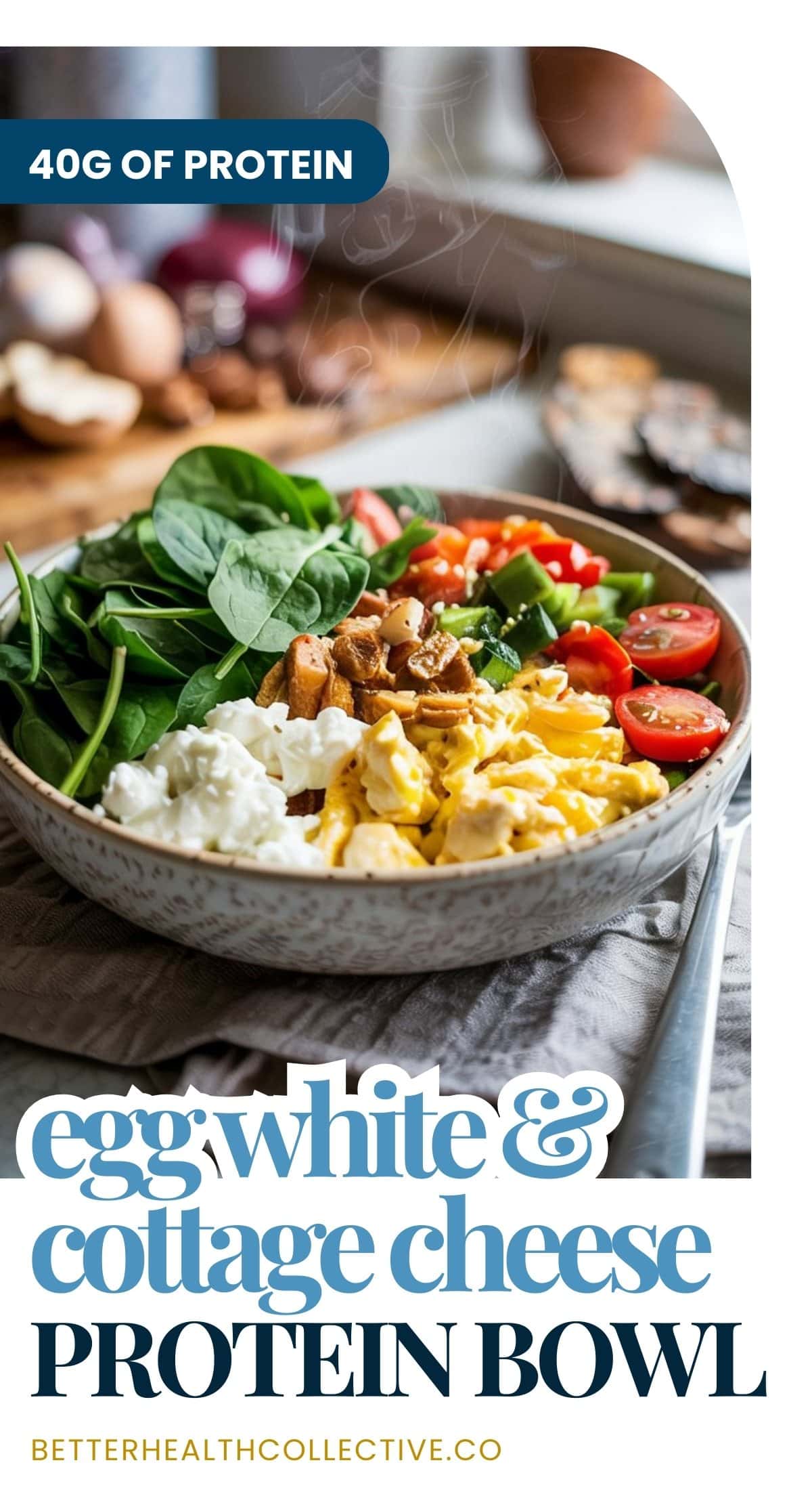 A protein bowl filled with egg whites, cottage cheese, spinach, cherry tomatoes, cucumber, and nuts sits on a table. Text reads, “40g of protein. Egg white & cottage cheese protein bowl. betterhealthcollective.co.”.