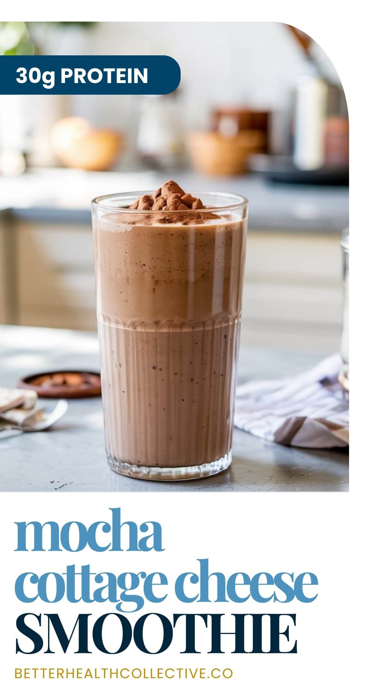 A tall glass of Mocha Cottage Cheese Smoothie topped with cocoa powder sits on a kitchen counter, with the text “30g protein” and “mocha cottage cheese smoothie” shown on the image.