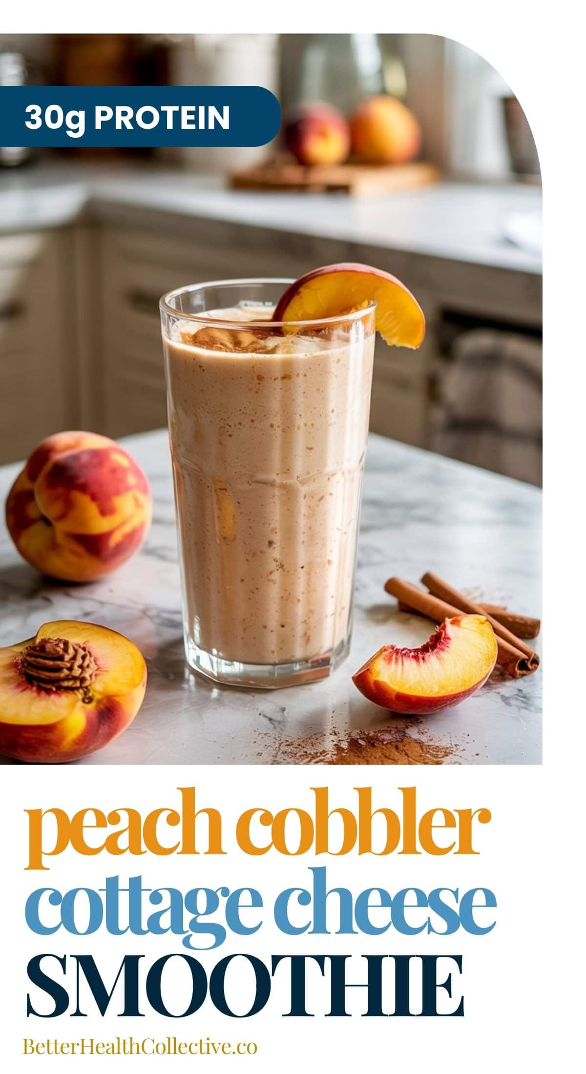 A glass of peach cobbler cottage cheese smoothie garnished with a peach slice sits on a marble counter, surrounded by fresh peaches and cinnamon sticks, with a kitchen in the background. Text reads 30g protein.