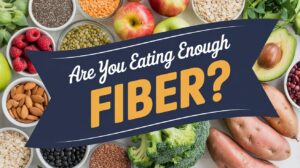 A banner reading Are You Eating Enough Fiber? over a background of fiber-rich foods, highlighting common low fiber symptoms and the importance of avoiding fiber deficiency with apples, broccoli, sweet potatoes, avocado, raspberries, almonds, oats, beans, and seeds.